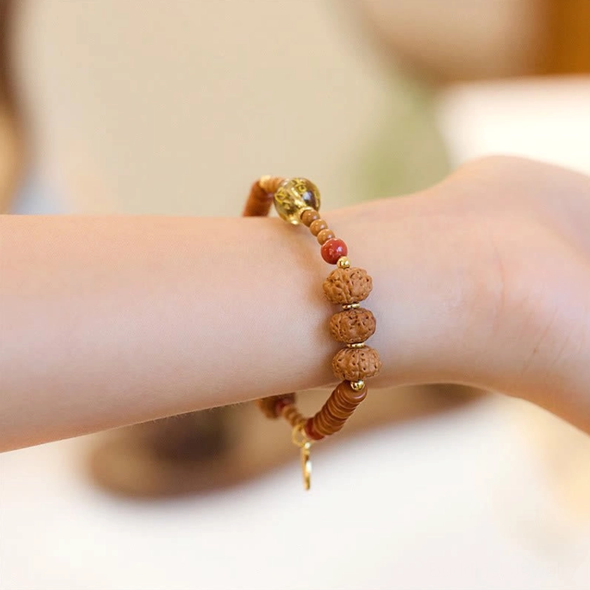 Double-layer Bodhi seed bracelet with red beads and clear gold bead worn on wrist