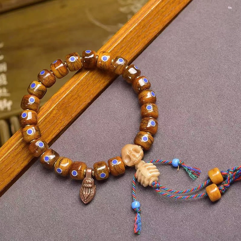 Double skull bone bracelet with woven tassels and beads representing Buddhist philosophy and impermanence