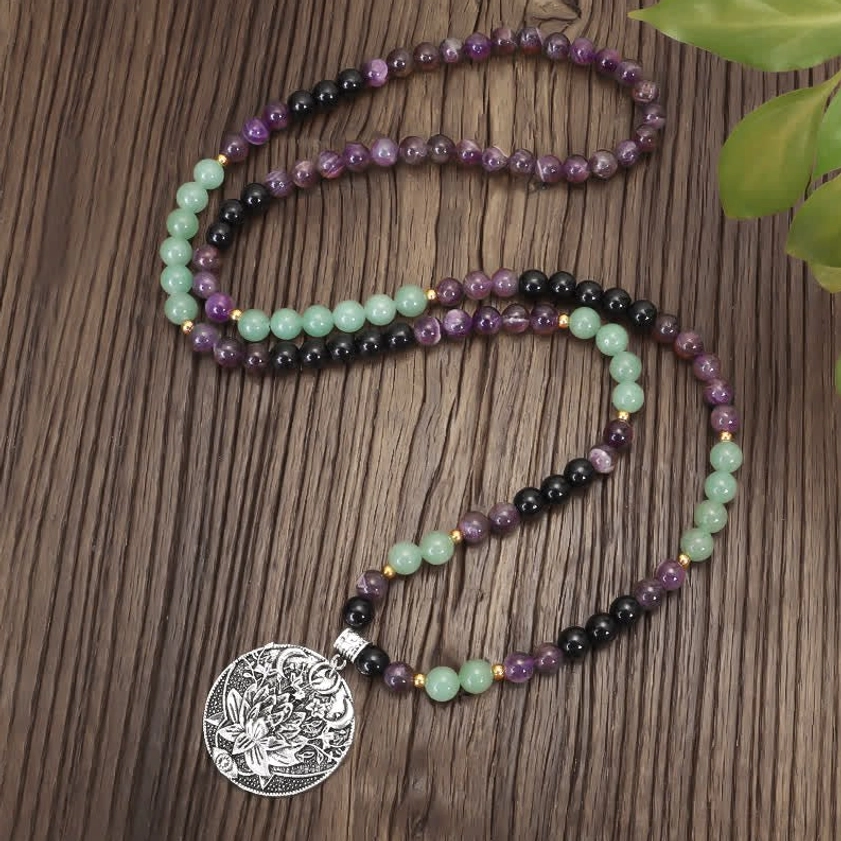 double-strand mala bracelet with amethyst and green aventurine beads, overhead view with decorative green leaf, authentic Buddhist prayer mala