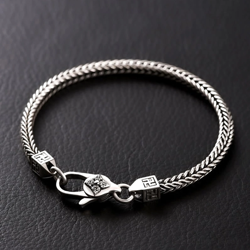 Double Vajra Buddhist bracelet with swastika symbol and lobster clasp, handmade copper chain displayed on dark leather background