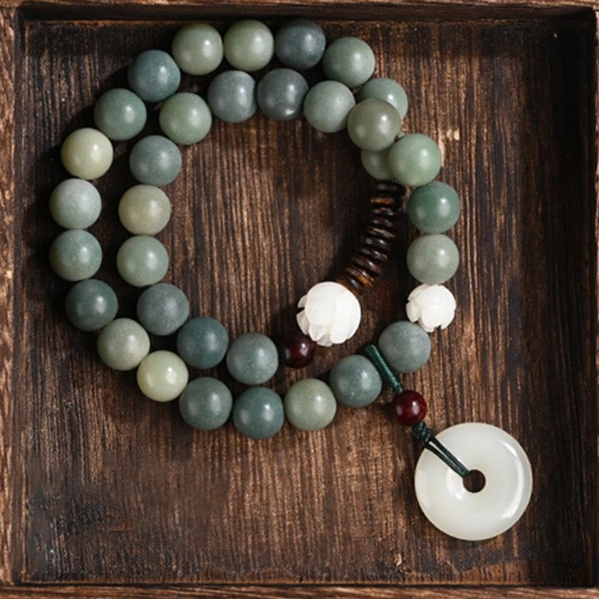 Double wrap cyan bodhi seed bracelet flat lay on wooden tray displaying complete design with white lotus bead and jade peace buckle charm