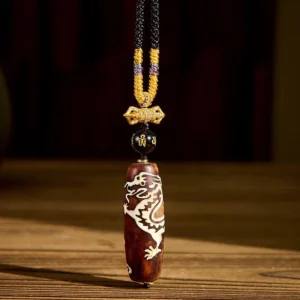 Dragon pattern agate dzi bead Buddhist necklace pendant with white dragon motif on reddish-brown stone, gold accents, and hand-woven braided cord