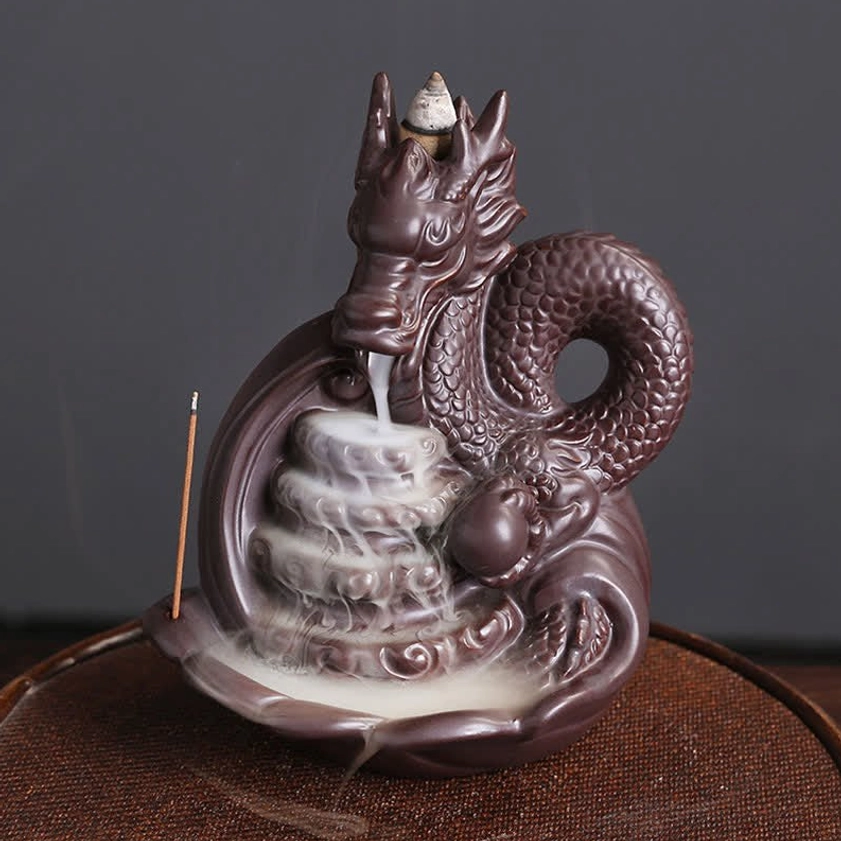 Dragon ceramic backflow incense burner with detailed scaled dragon design, dark brown matte finish, featuring flowing incense smoke in front three-quarter view on wooden surface