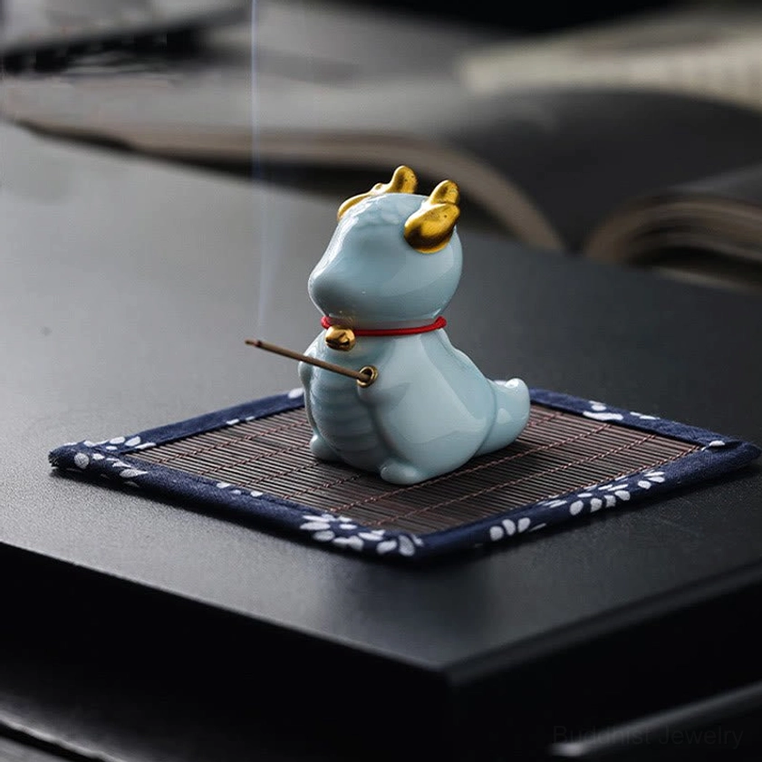 Burning dragon bell incense holder side rear view with light blue ceramic body and golden horn details