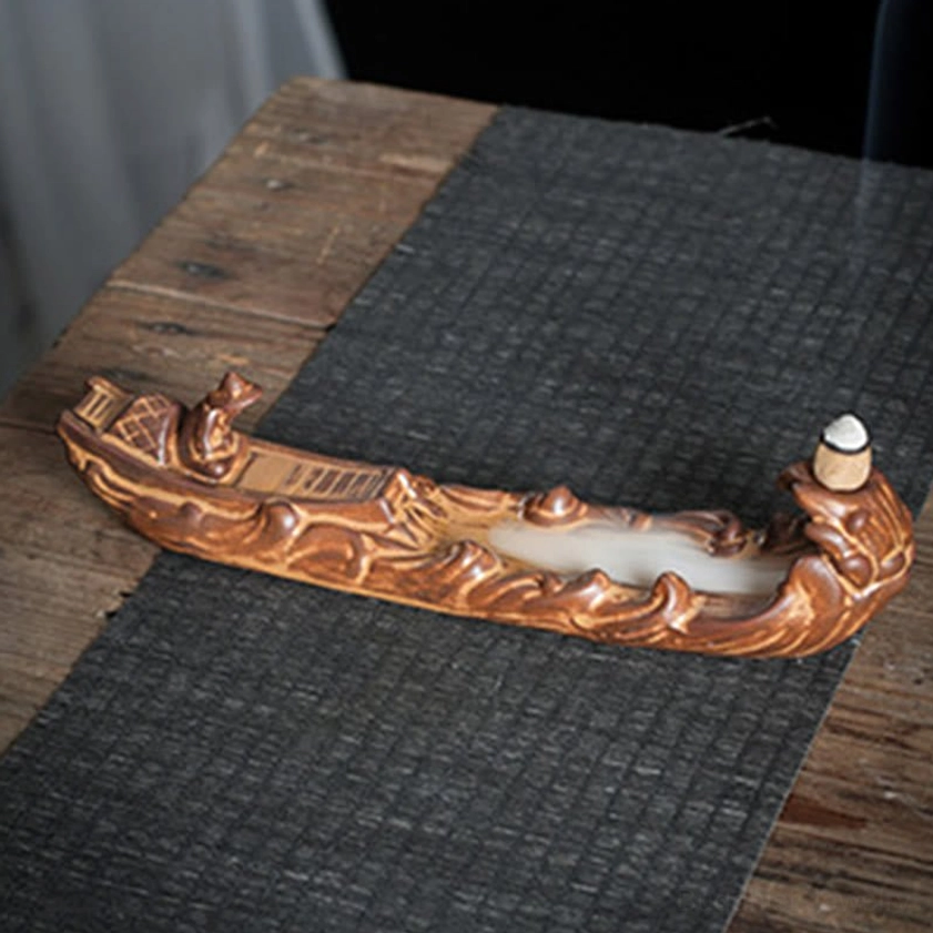 Dragon boat style ceramic incense burner with mythical dragon head and backflow incense groove on dark woven mat