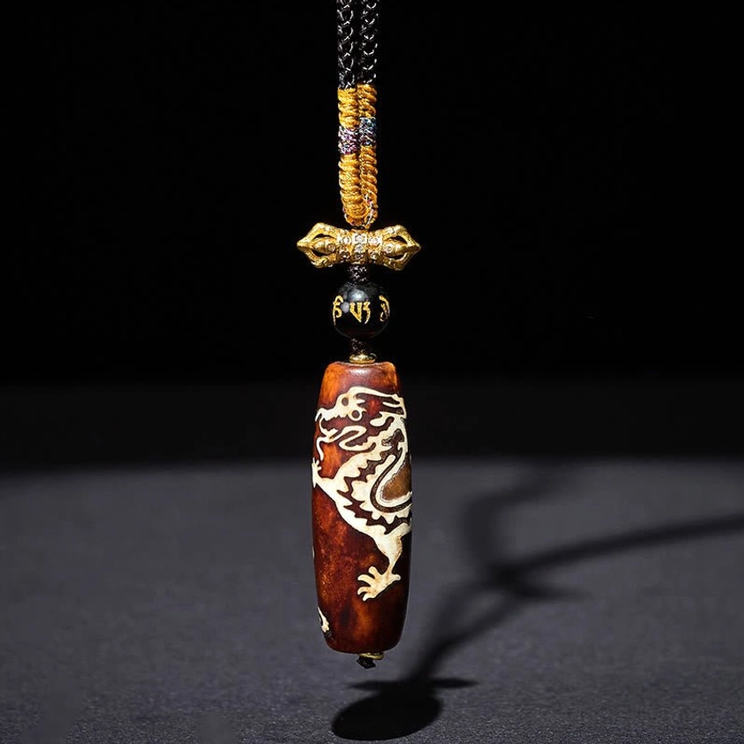 Hanging nine-eye dzi dragon pendant necklace in vertical display showing complete length and agate stone details with studio lighting