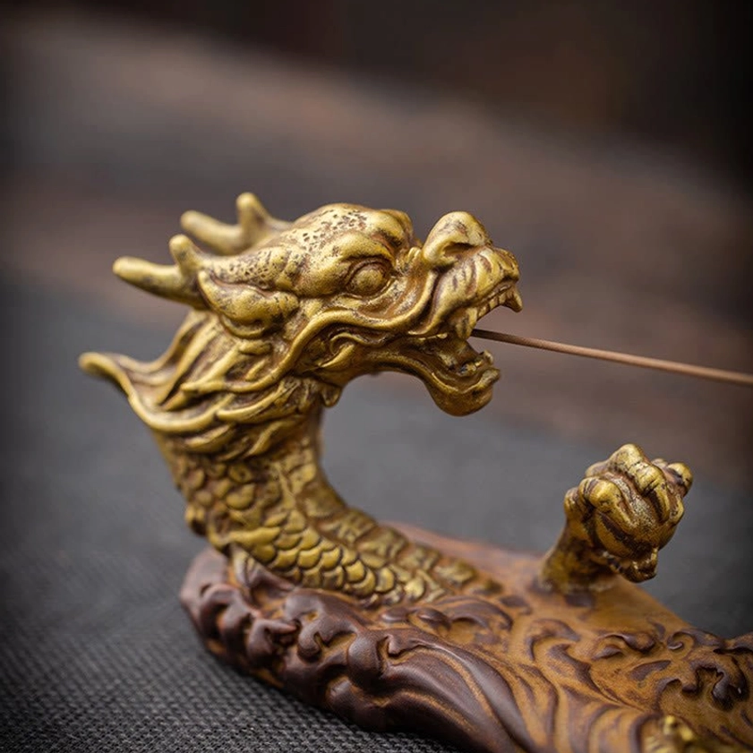 Front close-up view of ceramic dragon incense burner showing detailed gilded dragon scales and facial features with burning incense