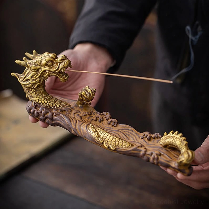 Hand-held dragon ceramic incense burner with rising incense smoke, low side angle view for scale and detail