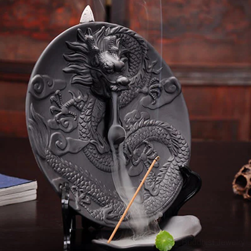 Side close-up of embossed dragon incense holder showing detailed carving and smoke pattern