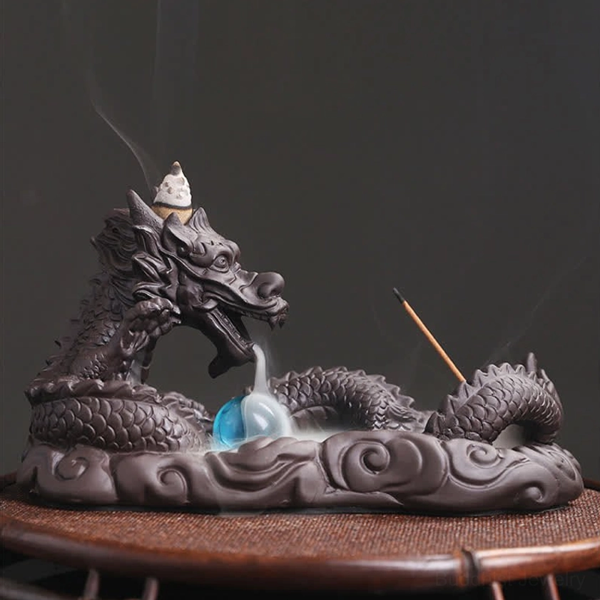 Dragon Buddhist incense burner front view with flowing smoke descending along ceramic sculpture, blue glass accent on display coaster