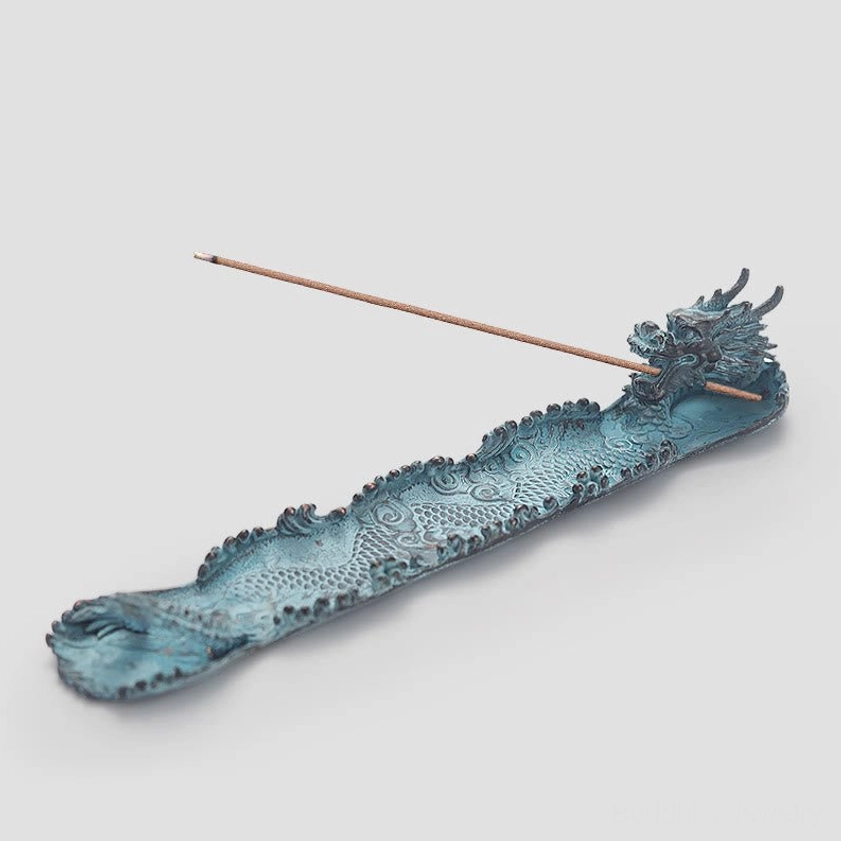 Dragon incense holder tray with incense stick on light gray background, flat overhead view showing full design