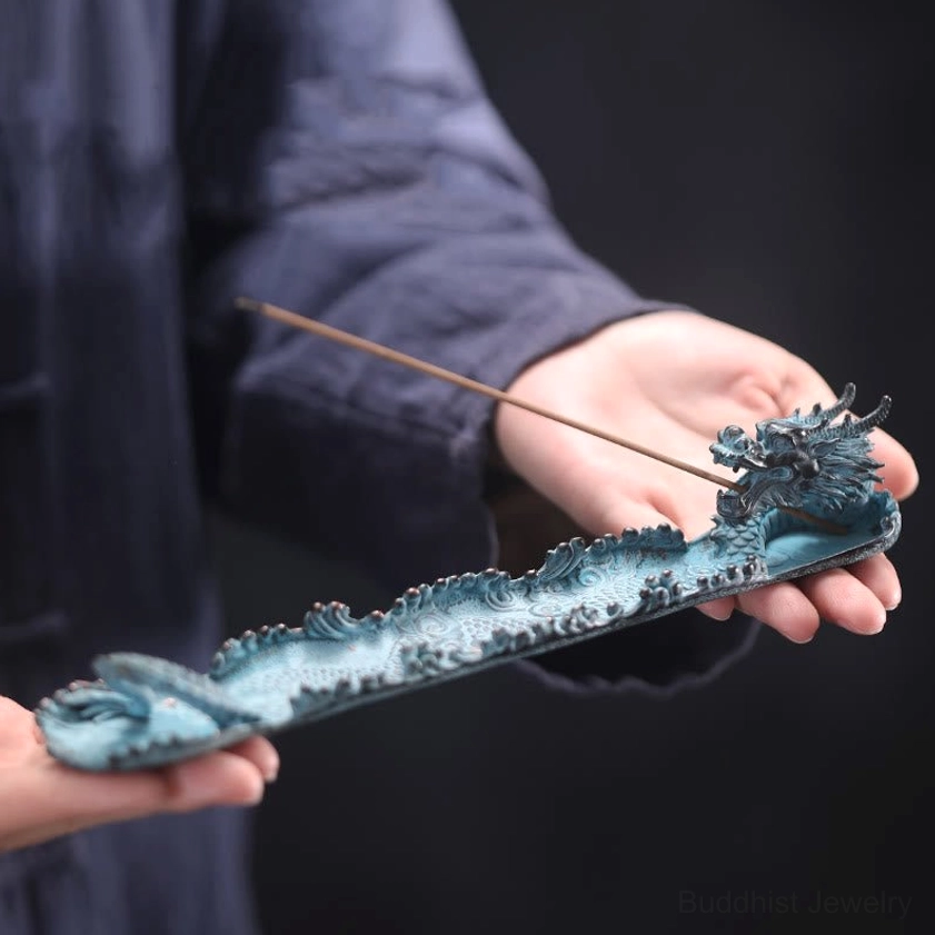 Handcrafted dragon incense holder tray held in hands, showing dragon head ornament and intricate carved details