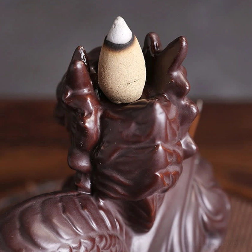Top-down view of dragon ceramic incense holder with beige backflow incense cone and carved dragon design