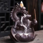 Dragon lotus backflow ceramic incense burner with carved dragon and lotus base, left front three-quarter view on traditional tea table, dark brown ceramic with incense stick