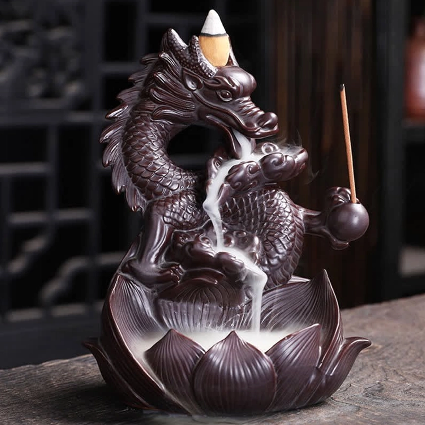 Dragon lotus backflow ceramic incense burner with carved dragon and lotus base, left front three-quarter view on traditional tea table, dark brown ceramic with incense stick