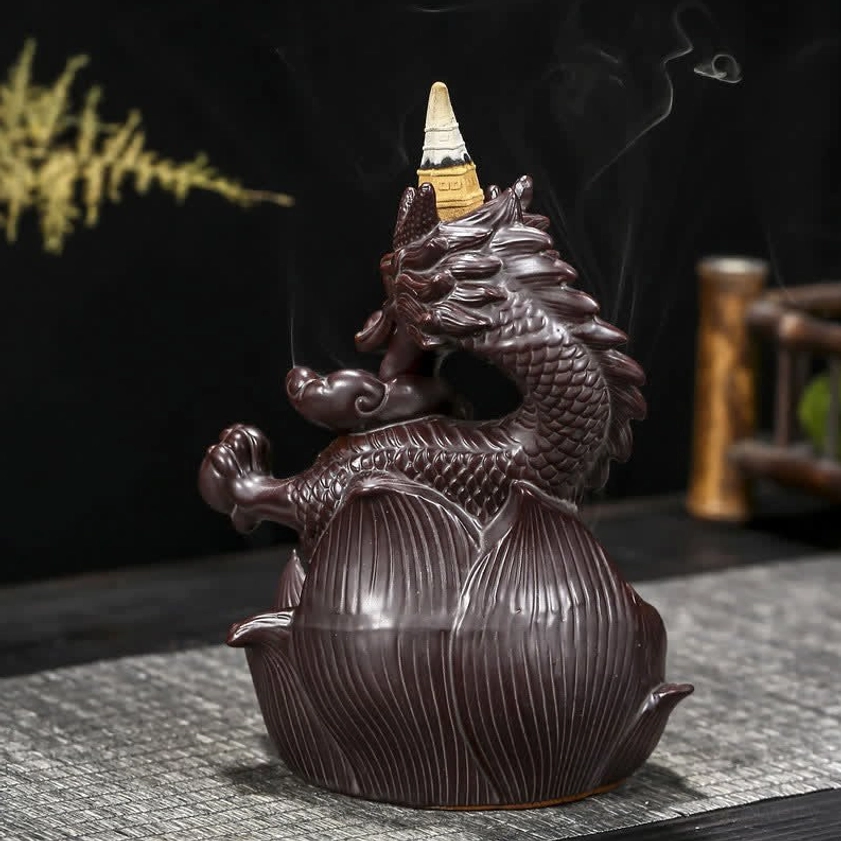 Rear three-quarter view of ceramic incense burner showcasing dragon and lotus base design with decorative plants in background