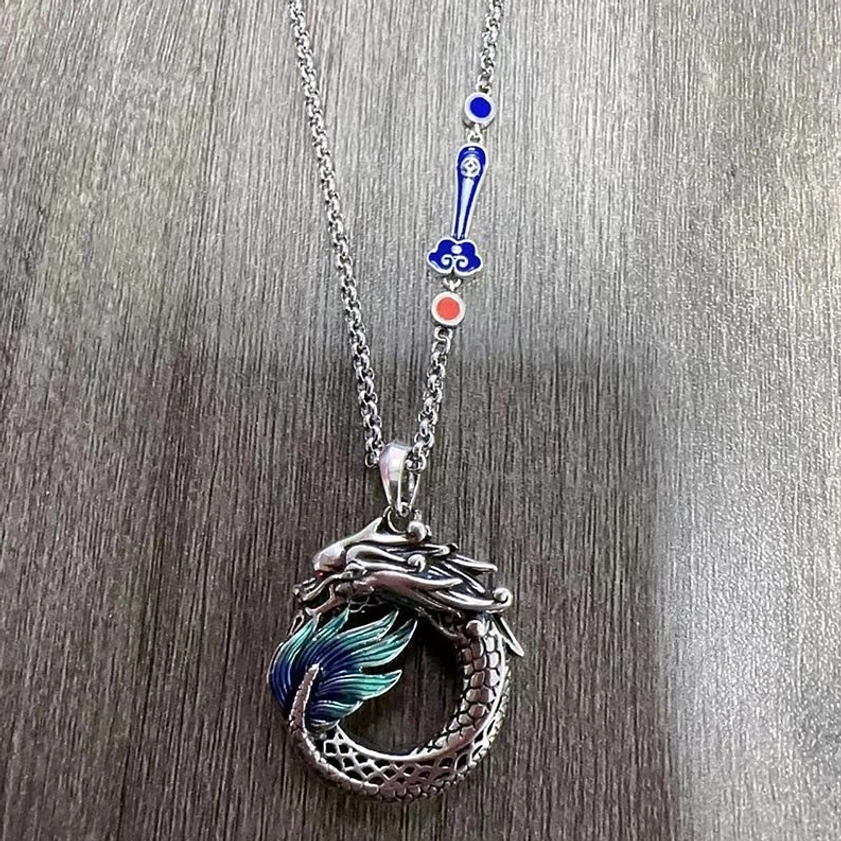Dragon pendant necklace with auspicious cloud chain, silver dragon pendant with blue and red enamel charms on wood background
