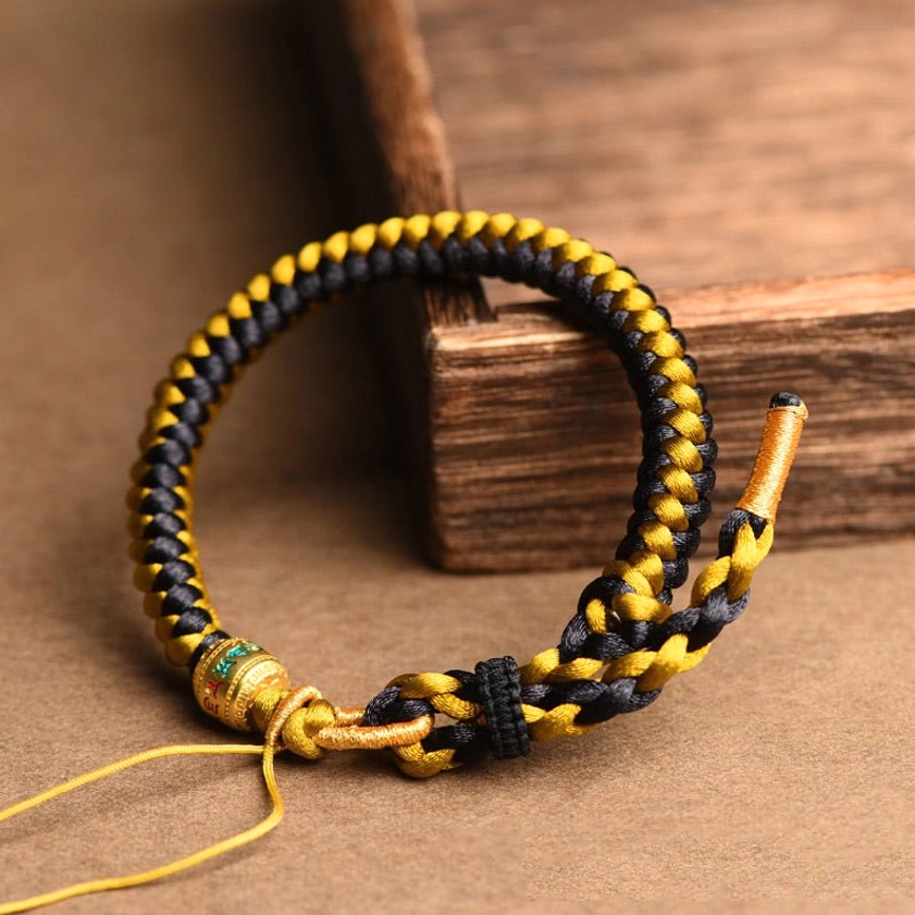 Macro detail shot of tight dragon scale knot pattern weave in black and gold silk cord