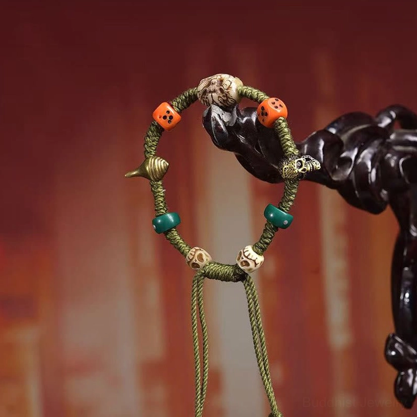Close-up overhead of adjustable Buddhist bracelet with hanging tassel and mixed vintage beads