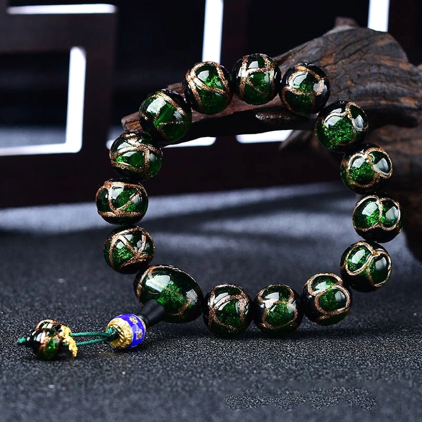 Dark green dragon vein agate bracelet close-up showing golden flecks and glossy finish