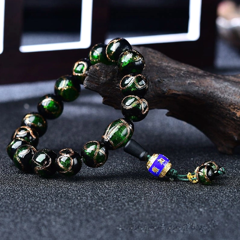 Dark green dragon vein agate beaded bracelet with enamel pendant on wooden background