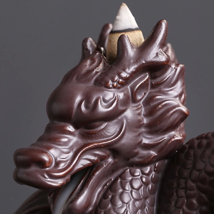 Extreme close-up of dual-dragon ceramic incense burner head showing highly detailed carved dragon facial scales and features