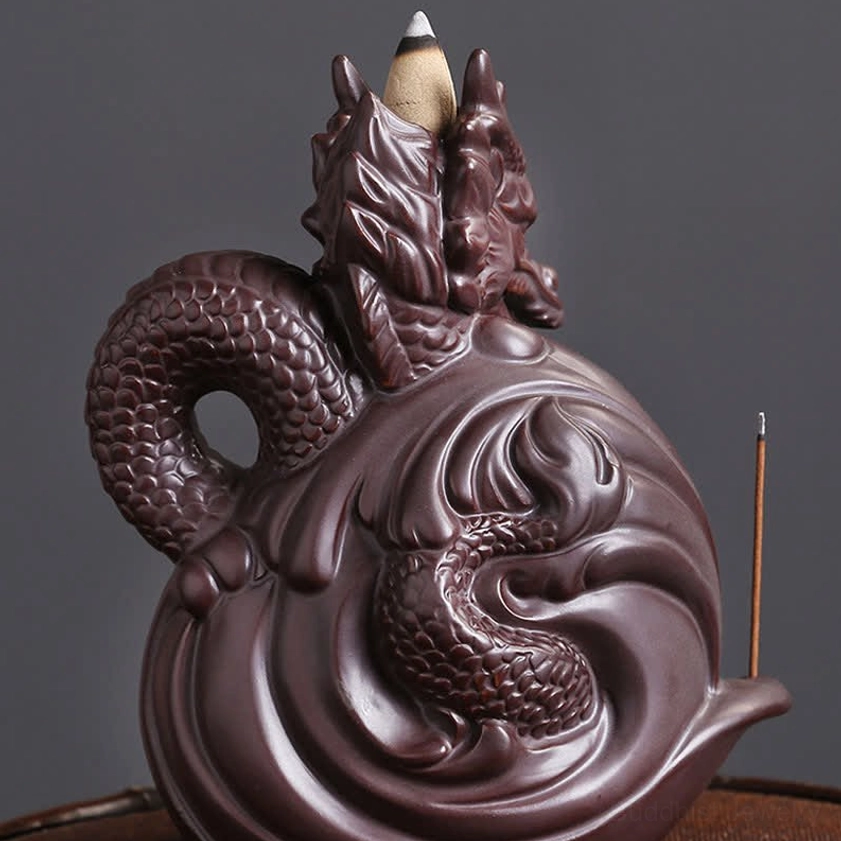 Dual-dragon ceramic backflow incense burner front view with swirling wave base pattern, detailed scaled dragon bodies with incense stick