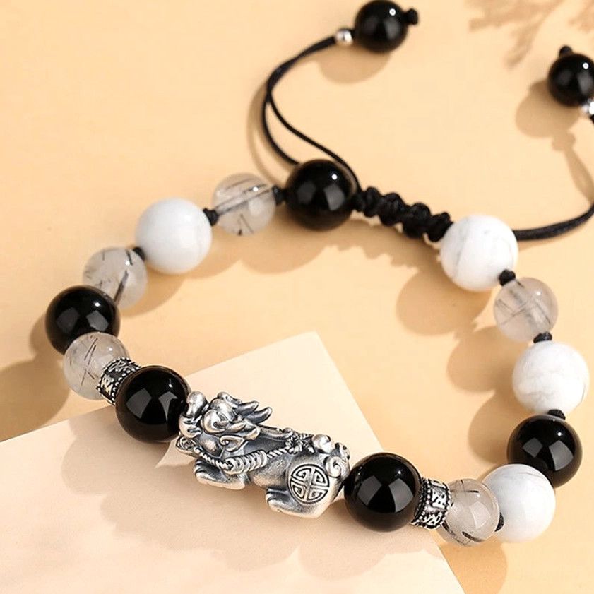Two Pixiu prosperity bracelets displayed flat lay, showing black obsidian white turquoise and chrysoberyl moonstone varieties