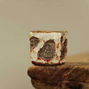 Dunhuang Buddhist Shino ceramic square tea cup with white crackle glaze and carved grotto motifs, front flat view on wooden surface