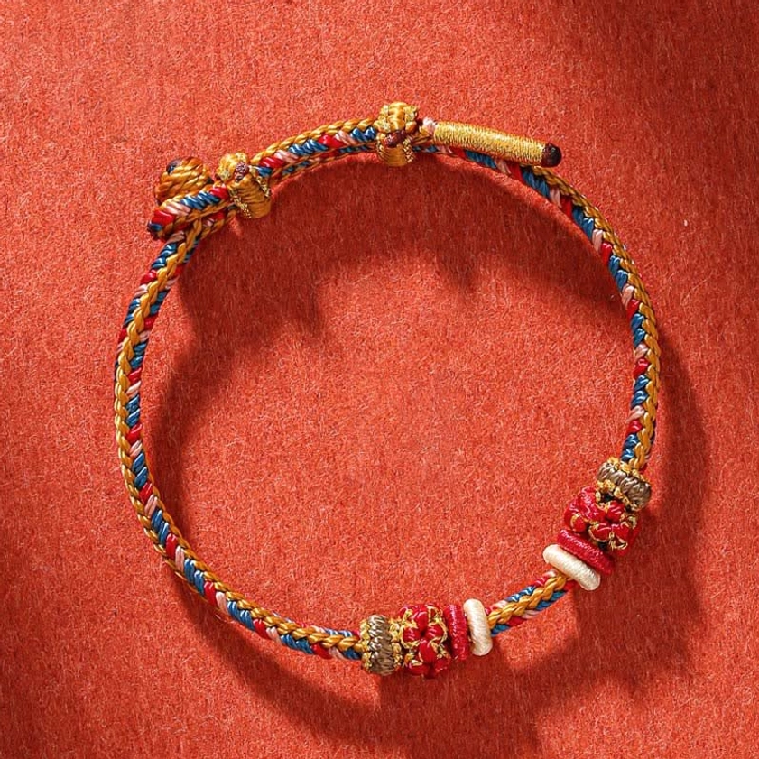 Dunhuang style Buddhist protection bracelet flat lay view showing intricate multicolor twisted cord weave and adjustable closure