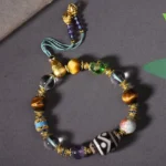 Dzi beads amethyst tiger eye Buddhist bracelet flat lay with protective gemstones displayed on dark background