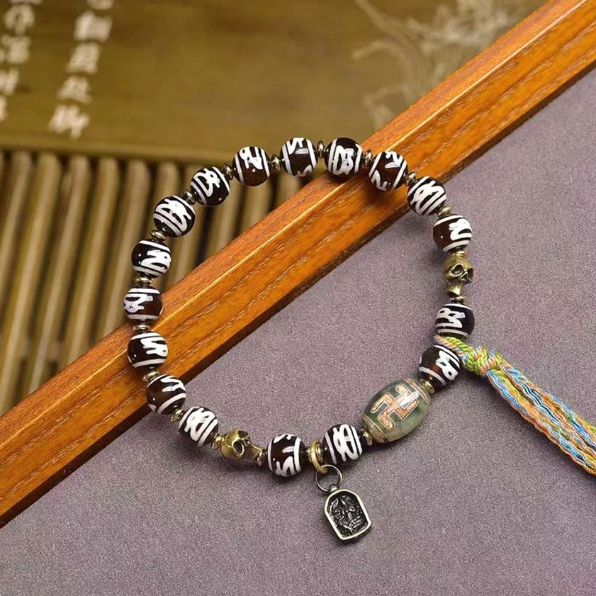 Buddhist prayer bracelet with hand-painted dzi beads, green agate, colorful woven tassel, and square charm pendant