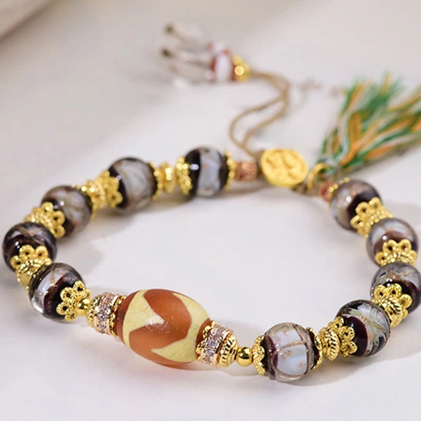 Hand-painted dzi bead protection bracelet with grey patterned spacer beads and gold hardware detail
