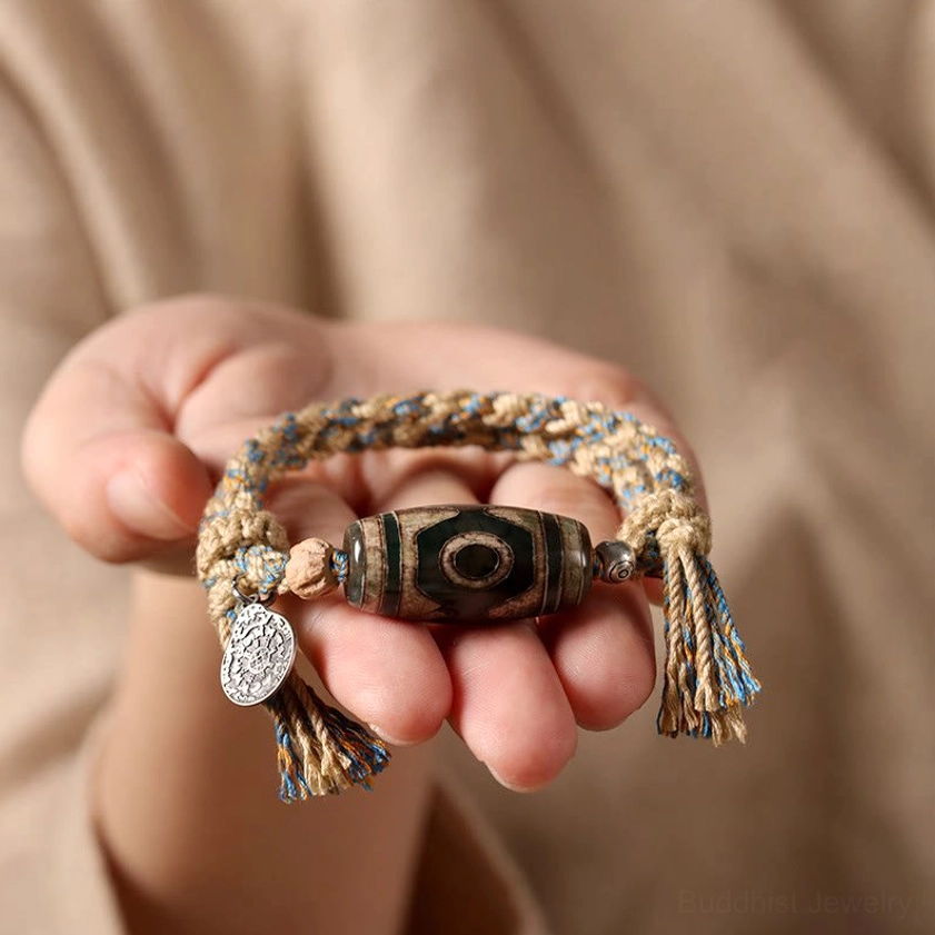 Handmade Dzi bead bracelet held in palms showing mixed woven rope texture and authentic craftsmanship