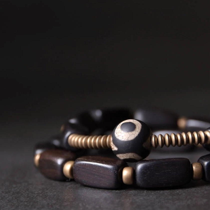 Close-up macro detail of nine-eye dzi bead with copper spacers and dark wood beads