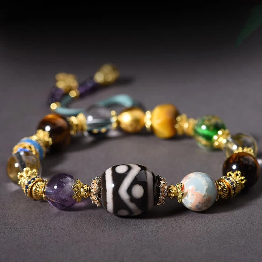 Side angle view of protective Dzi bead bracelet with amethyst and tiger eye showing central patterned stone