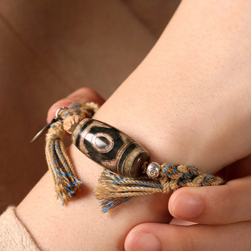 Adjustable dzi bead bracelet being worn on wrist showing tassel and spacer bead details