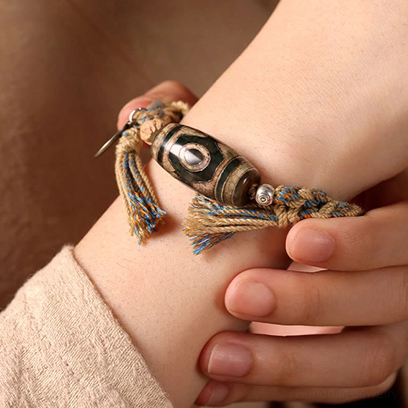 Buddhist Dzi bead string bracelet worn on wrist showing how authentic protection charm fits during daily wear