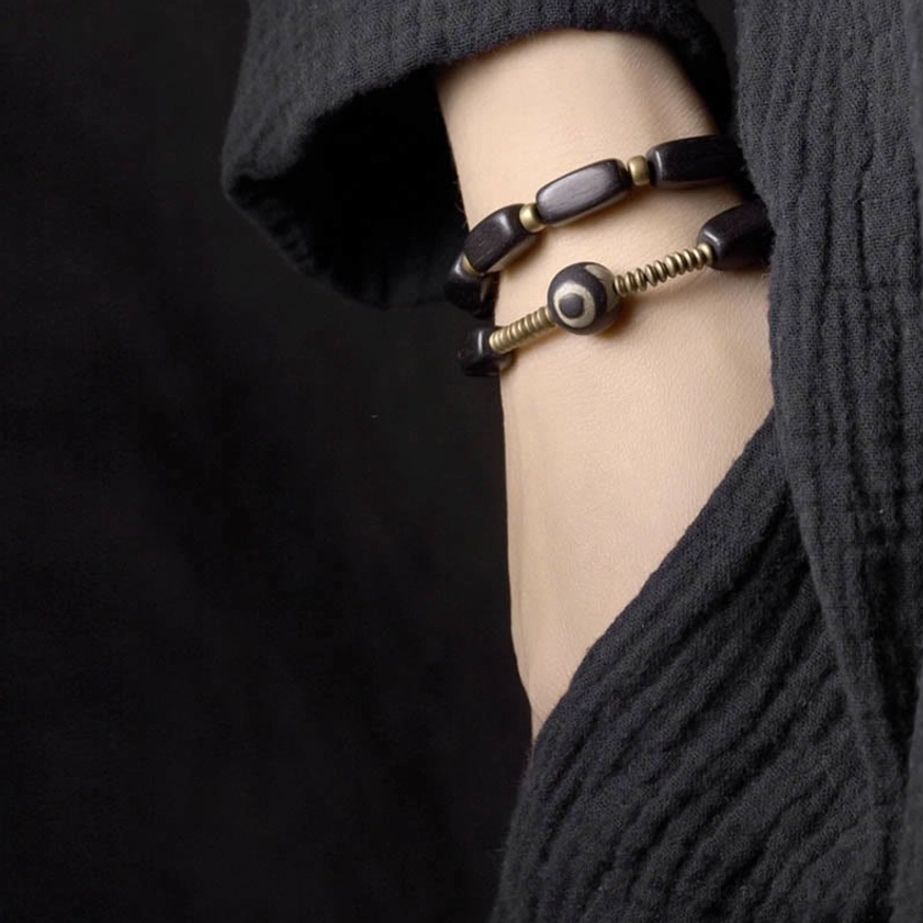 Buddhist ebony wood dzi bead bracelet worn on wrist showing double wrap fit