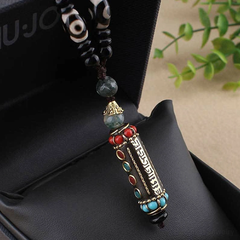 Hand-painted dzi bead Buddhist necklace showing sacred symbols and protective amulet craftsmanship