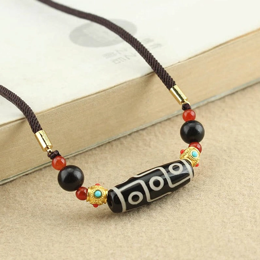 Nine-Eye Dzi Bead Buddhist necklace side view showing metal tube connectors and natural stone beading arrangement