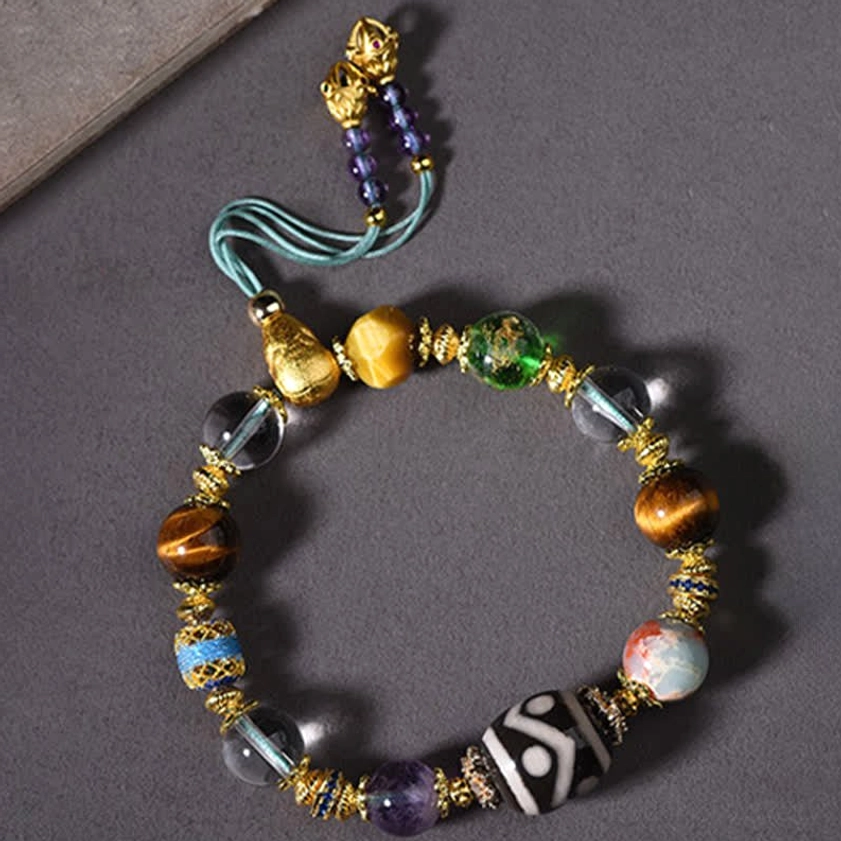 Close-up detail of hand-painted Dzi bead with intricate eye pattern on protective Buddhist bracelet