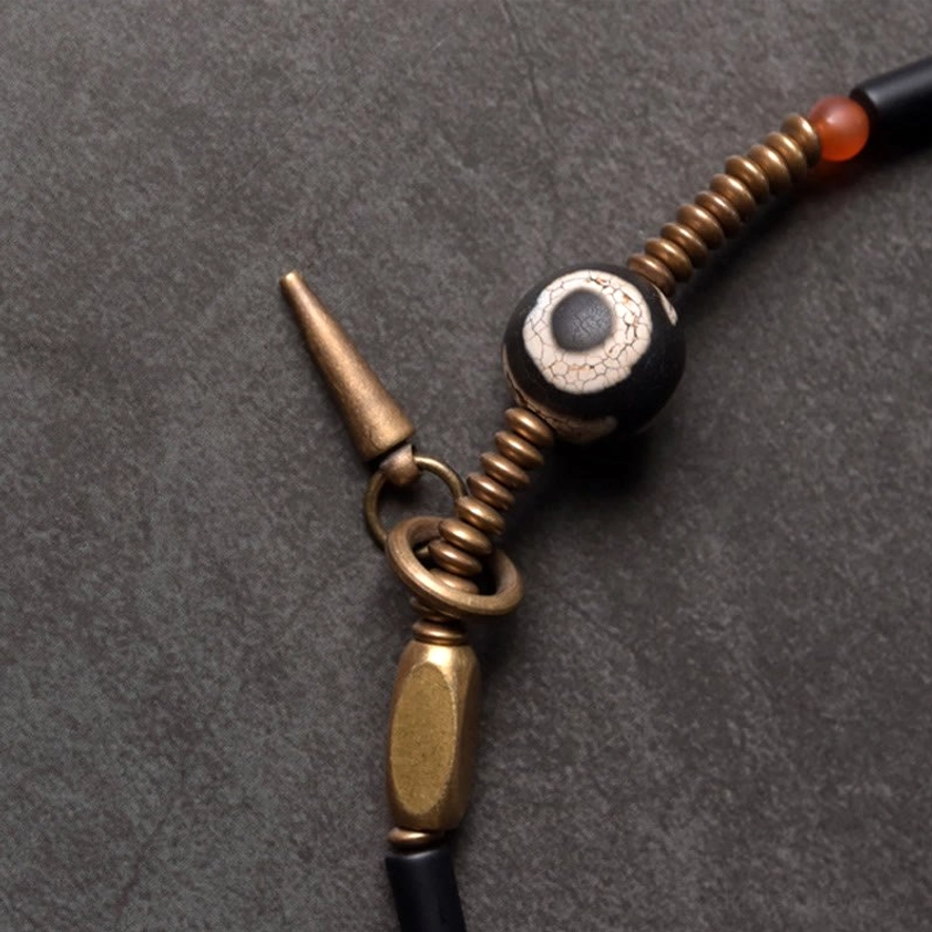 Antique copper clasp and Dzi bead charm focal point detail on protective Buddhist bracelet