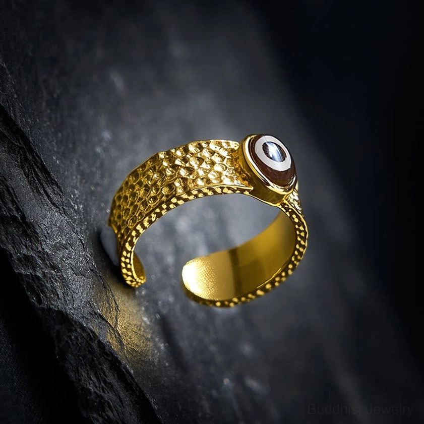 Copper dzi bead protective ring bottom side view, polished inner band with textured outer finish, slate stone backdrop