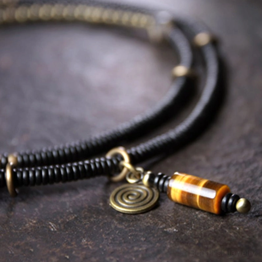 Hand-painted dzi bead and copper spiral charm close-up overhead view showing intricate beadwork and protective symbolism details