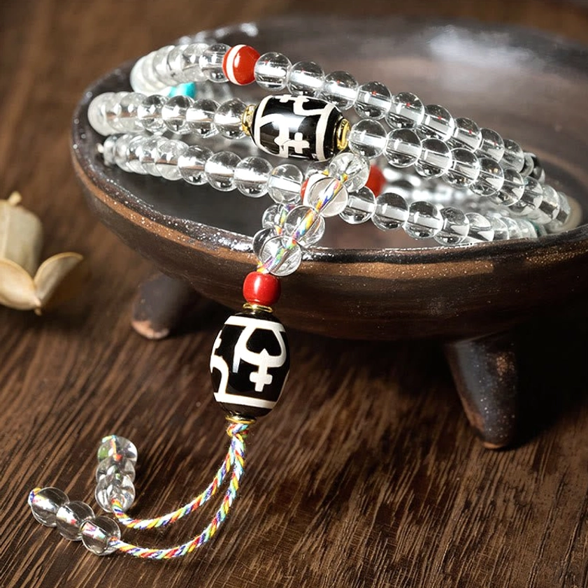 Close-up of hand-painted dzi bead mala with patterned black and white stone bead