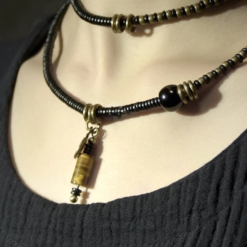 Choker-style double-strand dzi bead necklace close-up around neck showing hand-painted dzi bead detail and copper spacers