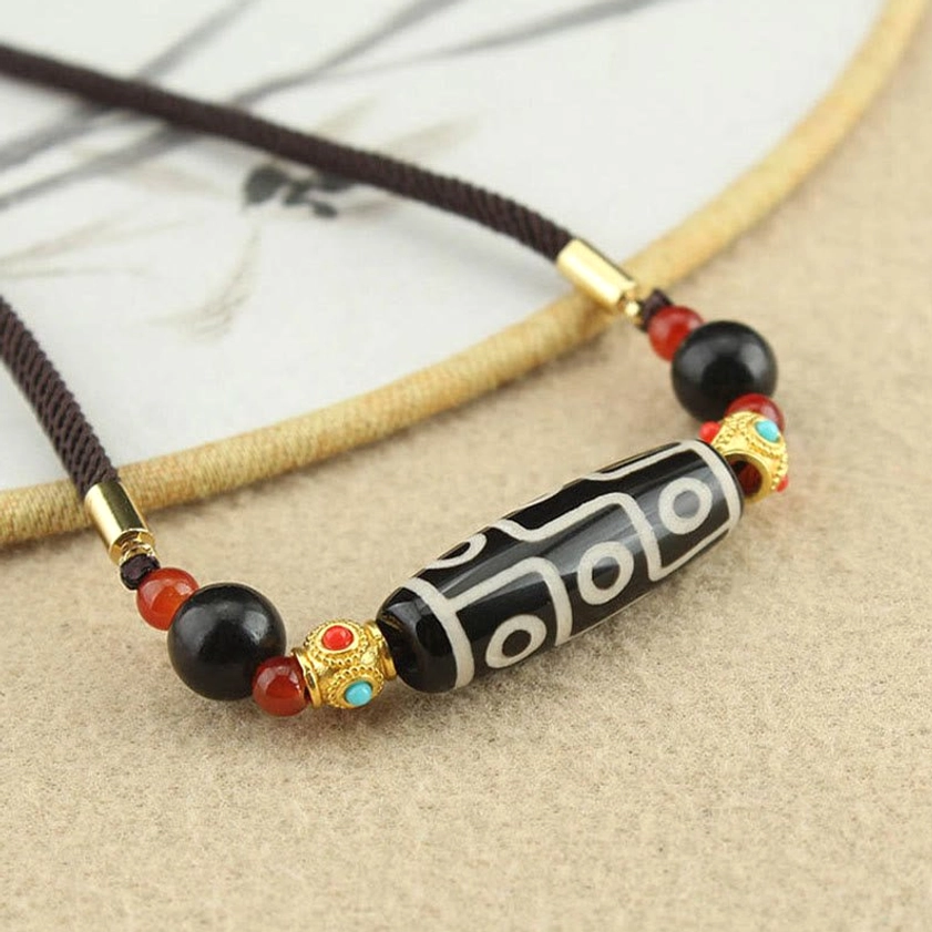 Nine-Eye Dzi Buddhist necklace showing gold-plated metal tube connectors and natural black agate red agate spacer beads