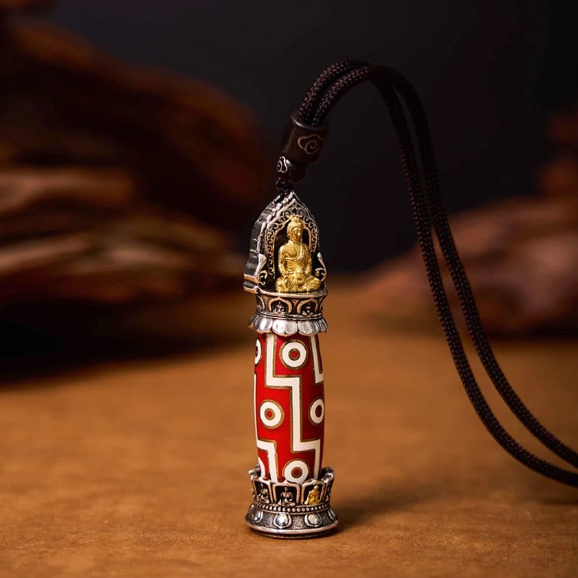 Buddhist healing necklace featuring Nine-Eye Dzi bead with traditional red-white design and gilt Buddha cap, three-quarter angle