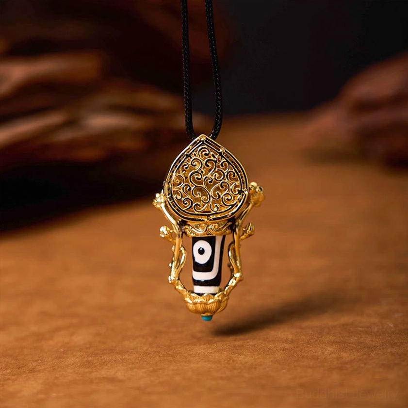 Hand-painted Dzi Bead pendant with gilded hollow carved copper top and blue decorative bead, flat front view showing intricate Buddhist protective amulet design